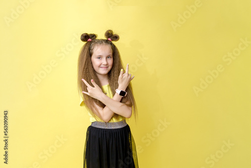 Cool cute girl with a trendy hairstyle in a yellow top on a yellow background with bright emotions