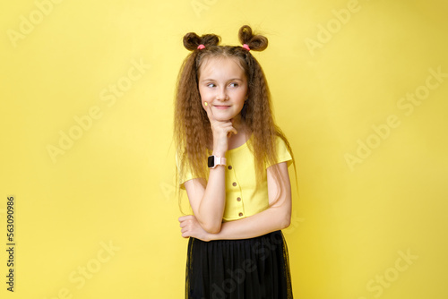 Cool cute girl with a trendy hairstyle in a yellow top on a yellow background with bright emotions