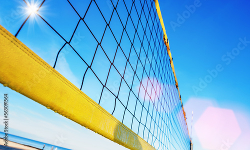 Part of volleyball net mounted on coastline on sandy beach photo