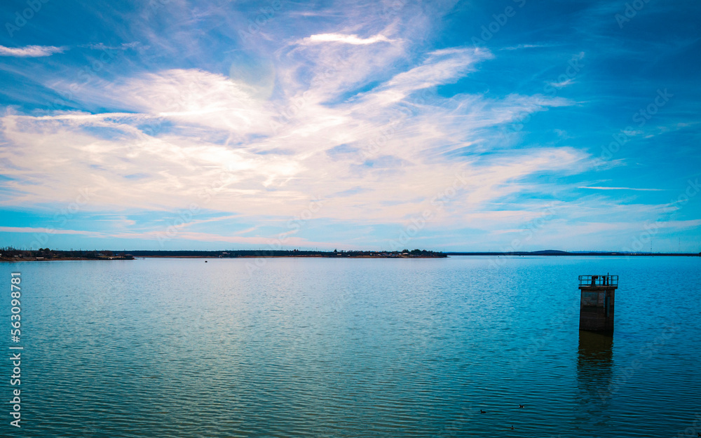 Tranquil bright sunny landscape of Lake Fort Phantom Hill in Abilene, Texas, USA, with dramatic cloudscape and lens flare
