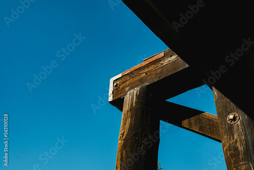 wooden beam structure detail, against blue sky