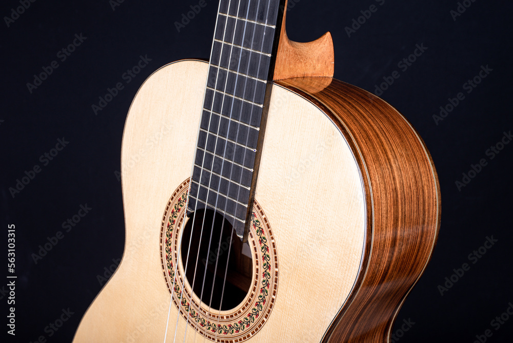 Classical guitar top isolated on black background with a beautiful mosaic rosette, view from the top side. Beautiful Brazilian wood - Pau Ferro on the back and spruce on the top. 