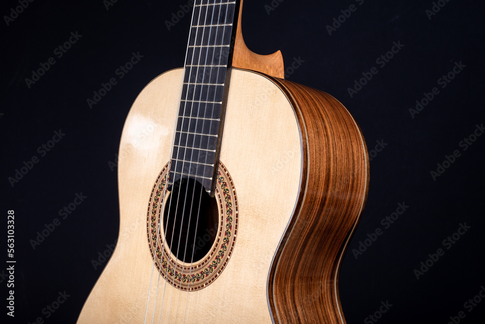 Obraz premium Classical guitar top isolated on black background with a beautiful mosaic rosette, view from the top side. Beautiful Brazilian wood - Pau Ferro on the back and spruce on the top. 