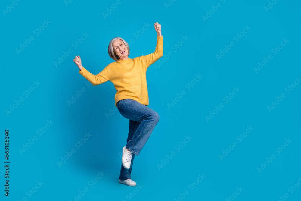Full body portrait of cheerful overjoyed person raise fists shout yes empty space ad isolated on blue color background Full body portrait of cheerful overjoyed person raise fists shout yes empty space ad isolated on blue color background