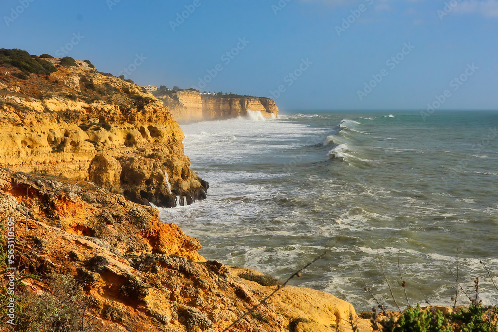 Waves in the Atlantic Ocean heading toward cliffs on a windy winter day in Carvoeiro, Portugal.