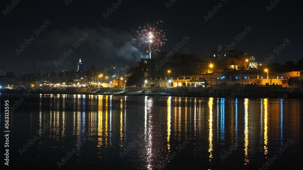 Fireworks display with light reflection on water on NYE - Manoel Island Malta