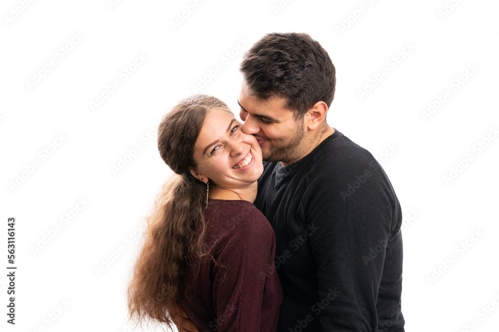 Male kissing woman on cheek as couple wearing casual clothing Male kissing woman on cheek as couple wearing casual clothing