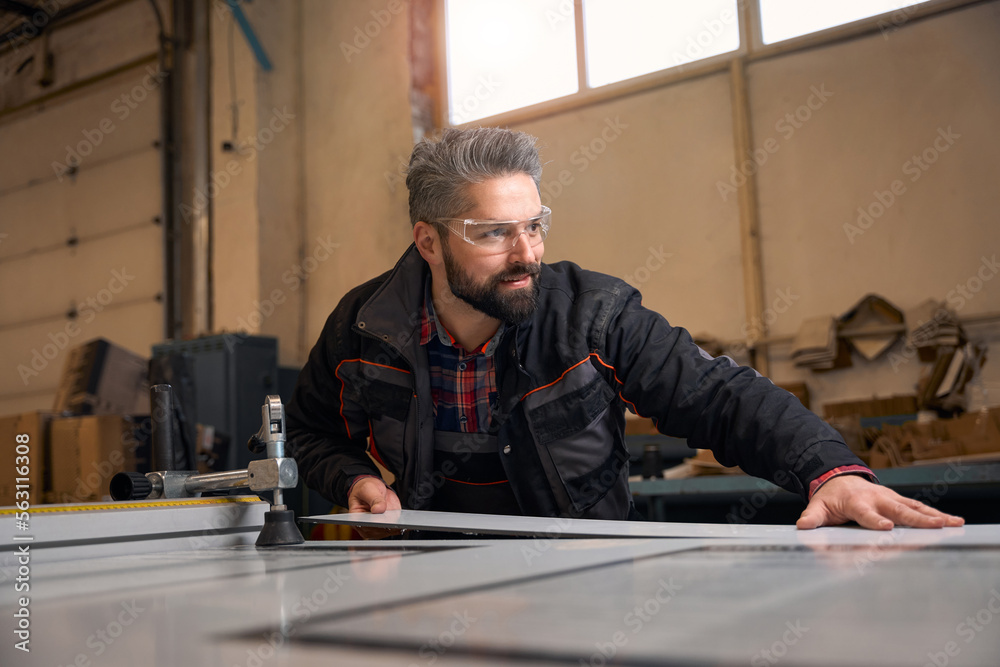 Portrait of handsome male cutting wood in workhouse Portrait of handsome male cutting wood in workhouse