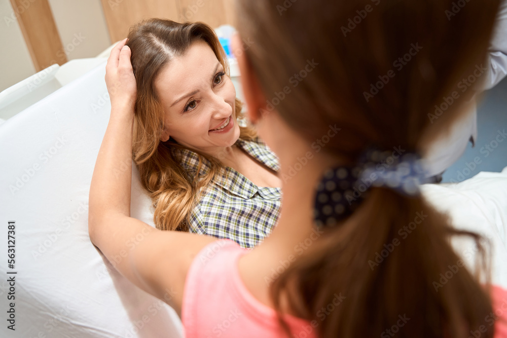 Fototapeta premium Young lady visits her mother in the hospital