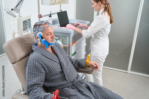 Man sits in medical chair with electrodes on his head