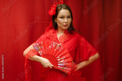 a girl in a red dress on a red background with a red fan