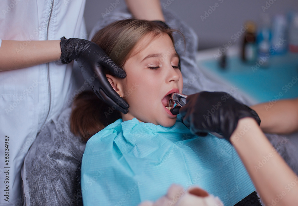 Dentist use anesthetic injection for tooth extraction in child. Stock