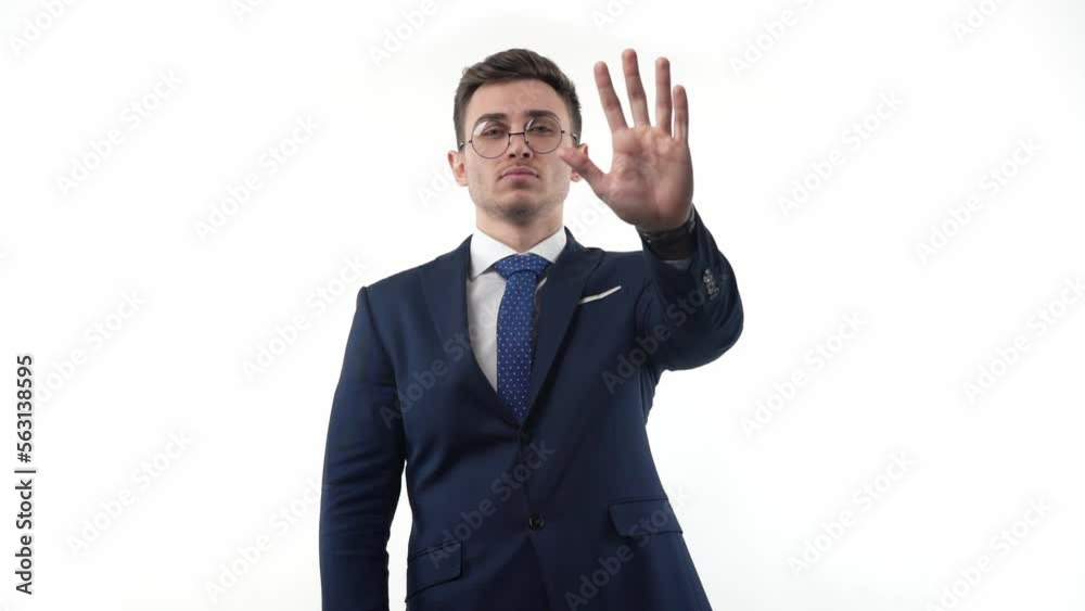 Man businessman in a suit and glasses on a white background shows an emotional gesture with his hand about the prohibition. Portrait Man businessman in a suit and glasses on a white background shows an emotional gesture with his hand about the prohibition. Portrait