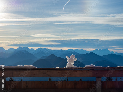 Lengries, Germany - December 28th 2022: A snowman enjoying the view towards the Alps on a beautiful winter day