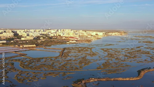 Beautiful aerial views of the Ria Formosa of Portuguese southern town of Faro, with salt lakes and houses. Drone movement up forward