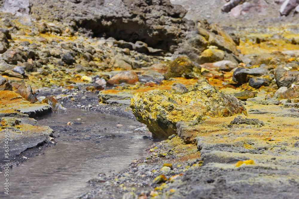 Sulphuric water stream with sulfur in the crater area of Whakaari, White Island volcano in new Zealand