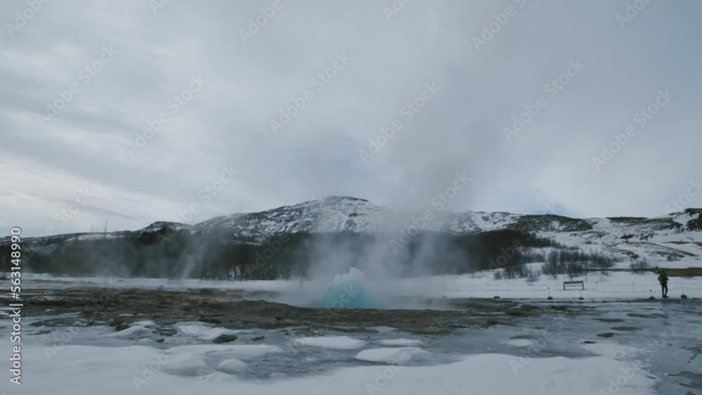 Natural geyser in Iceland. Landmarks of the golden ring in Iceland. Hot water in the geyser crater in winter Natural geyser in Iceland. Landmarks of the golden ring in Iceland. Hot water in the geyser crater in winter