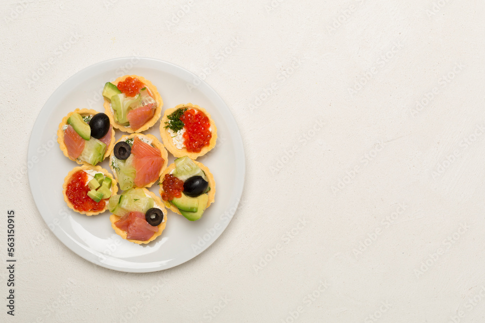 Tartlets with salmon and caviar on concrete background, top view Tartlets with salmon and caviar on concrete background, top view