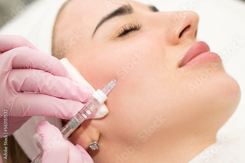 Close-up of the hands of an experienced cosmetologist injecting beauty into a woman s face. Filler correction and skin hydration