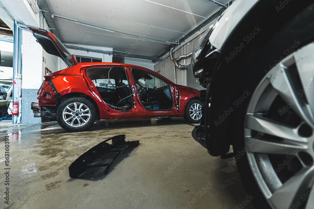 Red car body at repair shop, indoor background shot. High quality photo