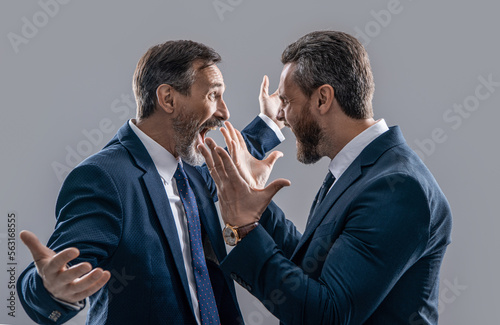 photo of businessmen arguing with aggression. two arguing businessmen isolated on grey
