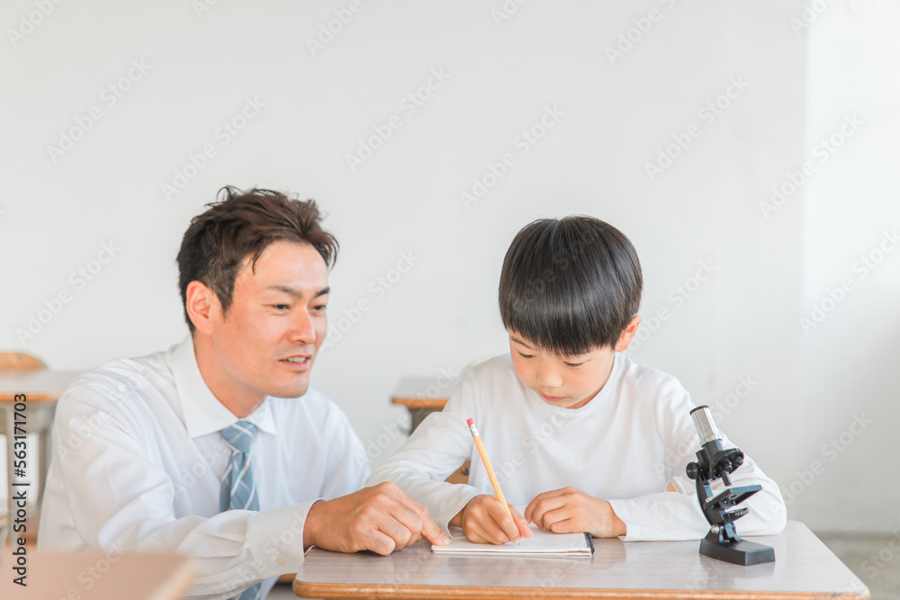 学校の授業で理科の実験・観察・研究・勉強をする小学生の男の子と先生・教師(顕微鏡)
学校の授業で理科の実験・観察・研究・勉強をする小学生の男の子と先生・教師(顕微鏡)