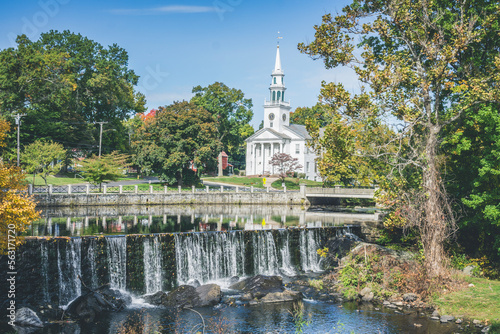 Milford, town in Connecticut. View of white church and waterfall surrounded by trees