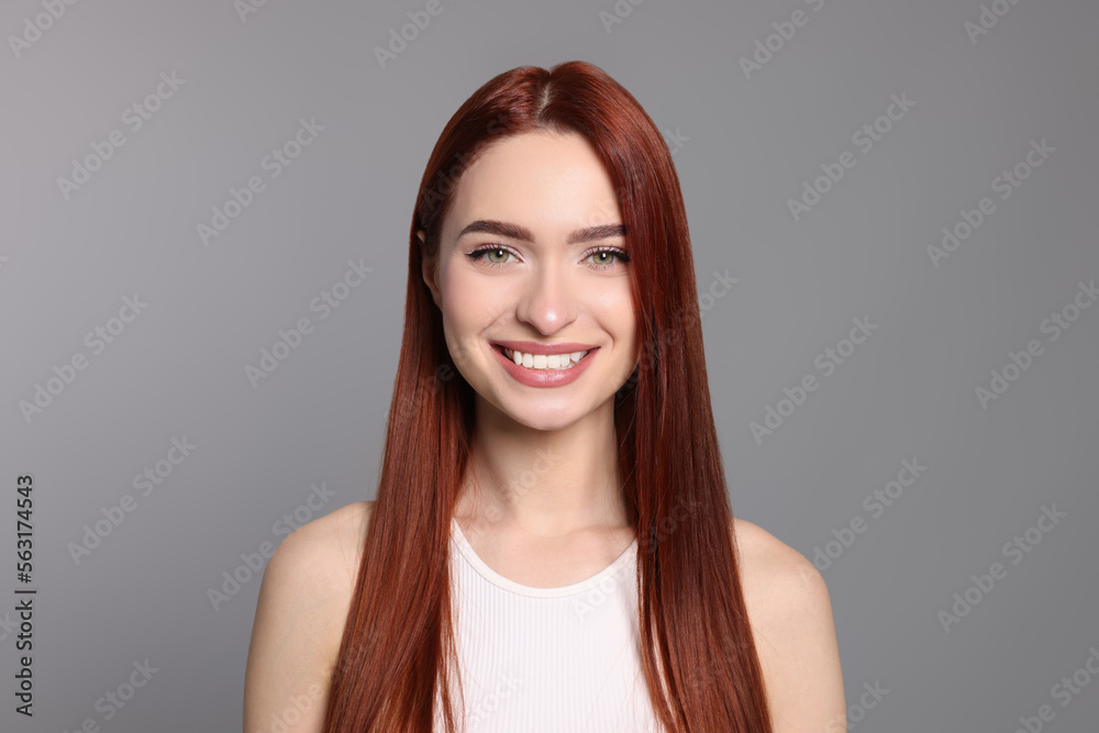 Happy woman with red dyed hair on light gray background Happy woman with red dyed hair on light gray background