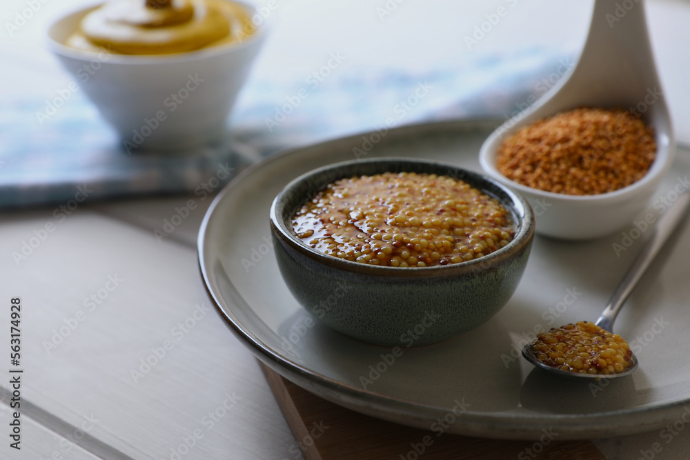 Bowl and spoon of whole grain mustard on wooden table. Space for text Bowl and spoon of whole grain mustard on wooden table. Space for text