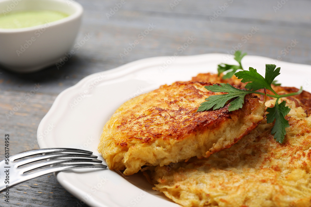 Tasty parsnip cutlets with parsley on grey wooden table, closeup Tasty parsnip cutlets with parsley on grey wooden table, closeup