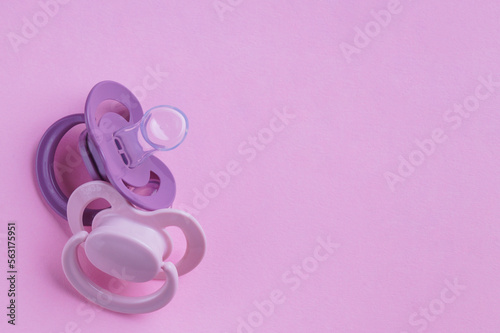 New baby pacifiers on pink background, flat lay. Space for text