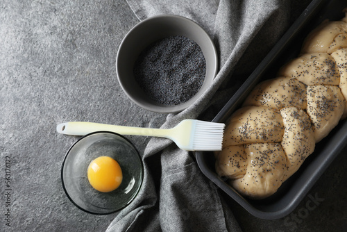 Homemade braided bread and ingredients on grey table, flat lay. Cooking traditional Shabbat challah photo