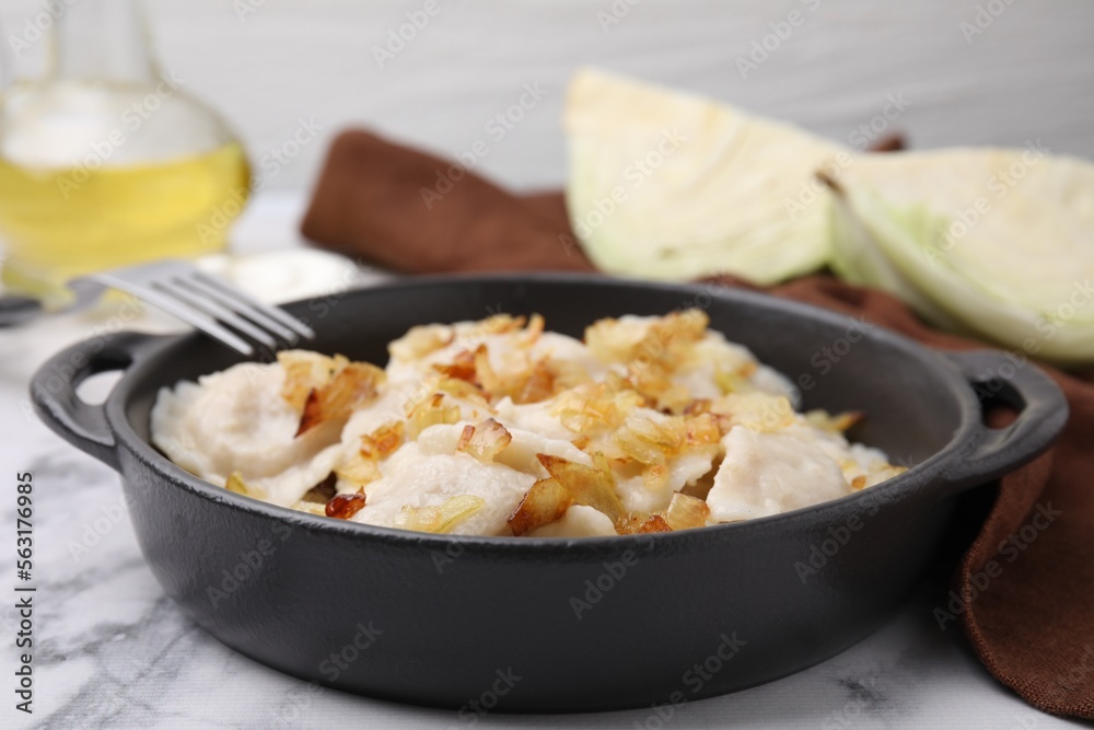 Cooked dumplings (varenyky) with tasty filling and fried onions on white marble table, closeup Cooked dumplings (varenyky) with tasty filling and fried onions on white marble table, closeup