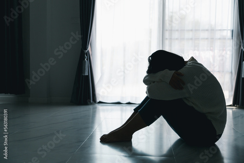 Concept of sad teenage girl depression. Upset teenage girl sitting at floor indoors. Anxiety young woman Despair and stress. Lonely and unhappy female are social victims. loneliness youth in home.