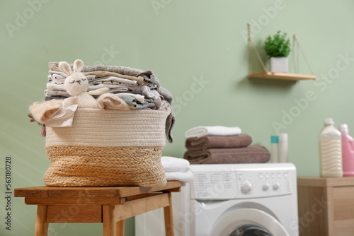 Laundry basket with baby clothes and toy on table in bathroom. Space for text © New Africa