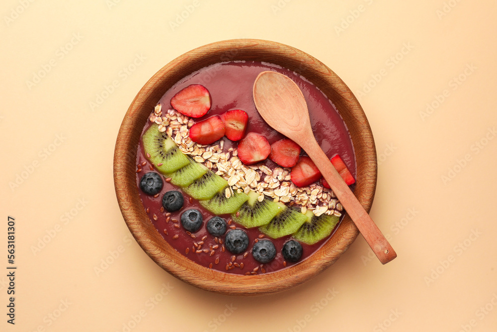 Bowl of delicious smoothie with fresh blueberries, strawberries, kiwi slices and oatmeal on color background, top view Bowl of delicious smoothie with fresh blueberries, strawberries, kiwi slices and oatmeal on color background, top view