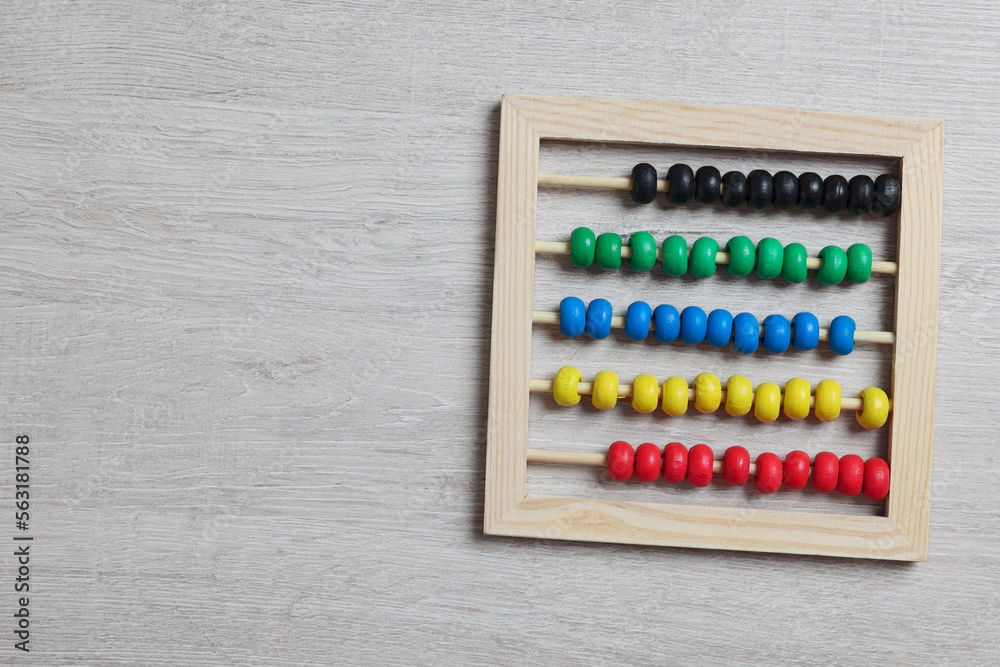 Funny math game. Colorful toy abacus on white wooden table, top view. Space for text Funny math game. Colorful toy abacus on white wooden table, top view. Space for text