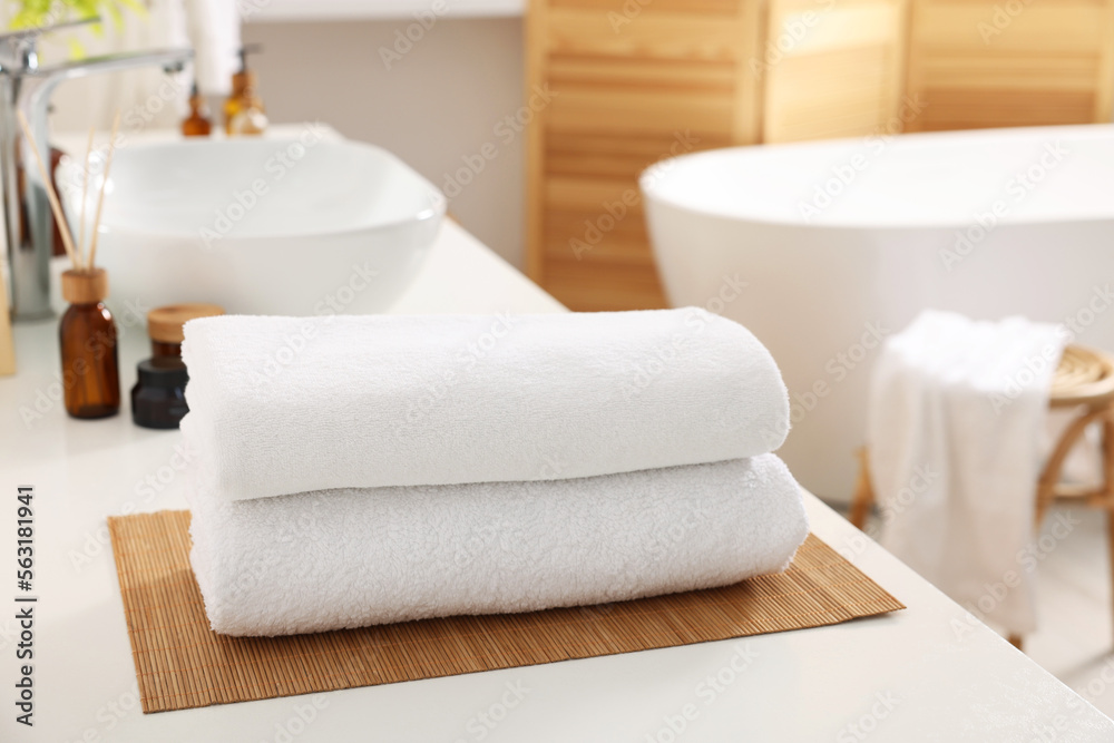 Stacked soft towels on white table in bathroom Stacked soft towels on white table in bathroom