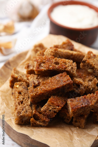 Delicious crispy rusks with sauce on white wooden table, closeup