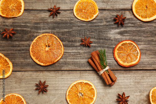 Flat lay composition with dry orange slices, anise stars and cinnamon sticks on wooden table