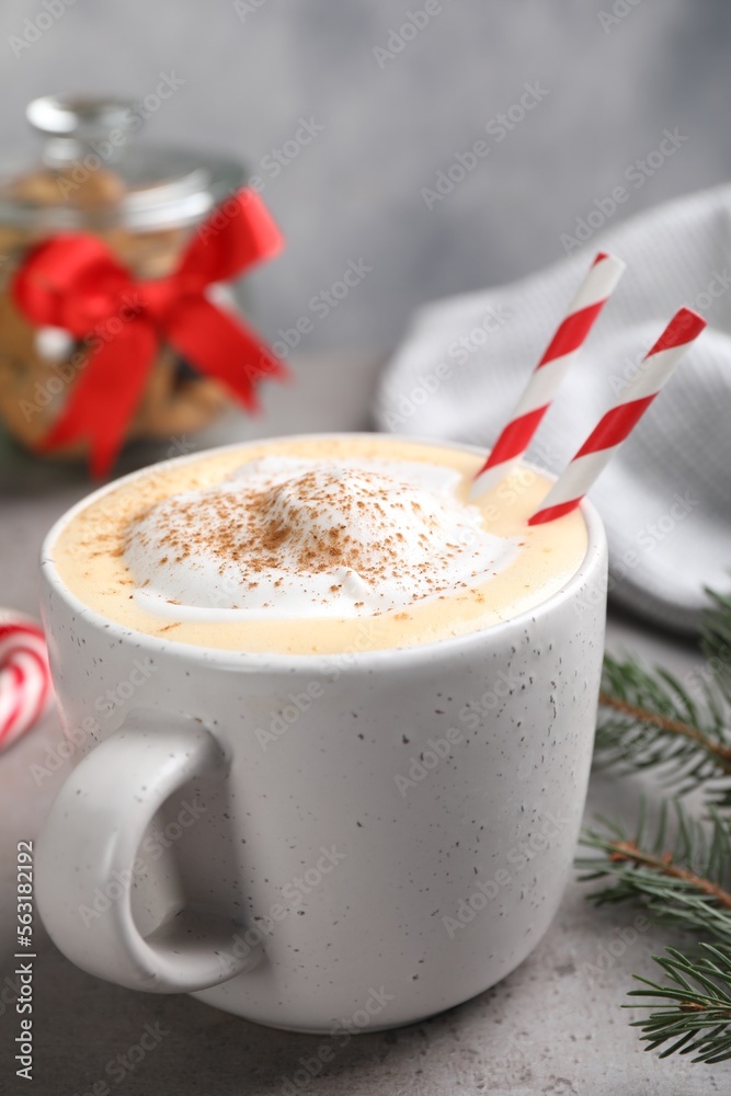 Cup of delicious eggnog with cinnamon on gray table, closeup Cup of delicious eggnog with cinnamon on gray table, closeup