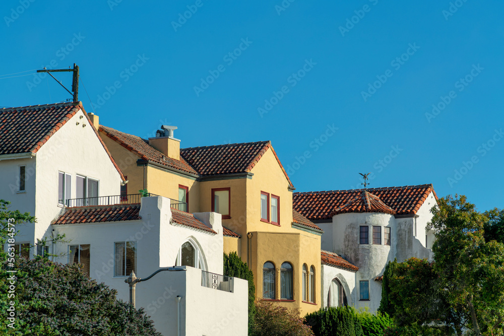 Row of modern houses in the historic districts of downtown san francisco california with front yard trees and blue sky