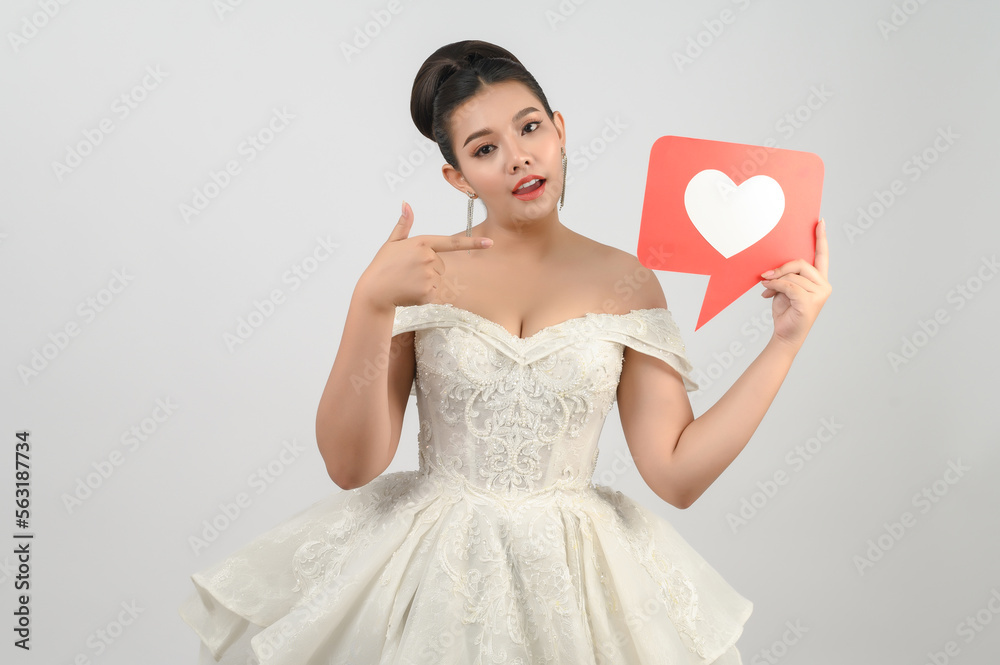 Asian beautiful bride smiling and posing with heart sign on white background Asian beautiful bride smiling and posing with heart sign on white background