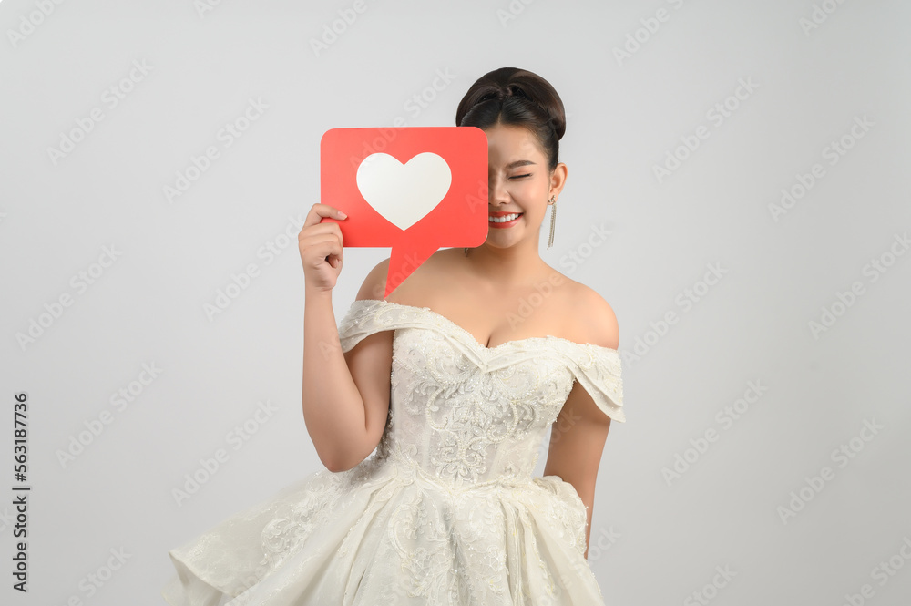 Asian beautiful bride smiling and posing with heart sign on white background Asian beautiful bride smiling and posing with heart sign on white background