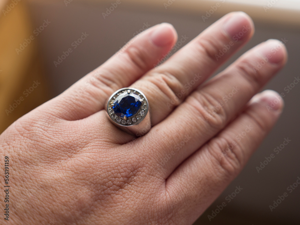Blue stone silver ring on finger, close up Blue stone silver ring on finger, close up