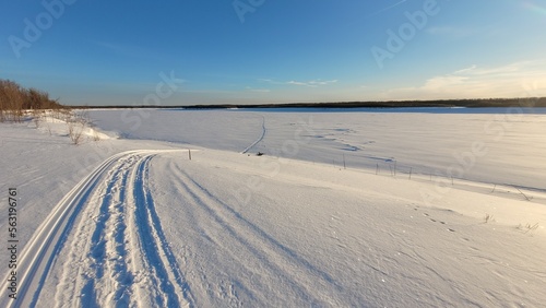 Beautiful winter landscape. Snow covered river. Tracks