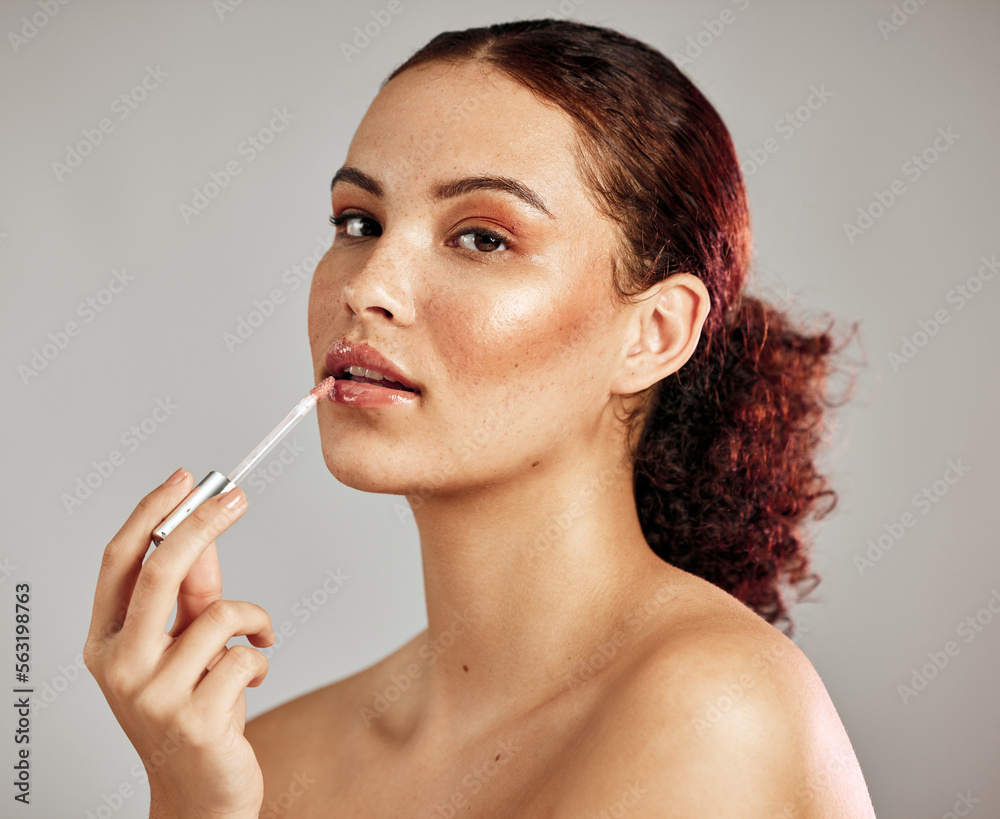 Woman, makeup portrait and lip gloss application for beauty, cosmetics dermatology and skincare wellness in grey background. Female model, face and lipstick brush or lip balm product for self care - obrazy, fototapety, plakaty 