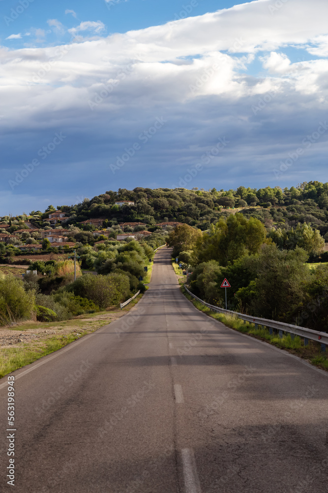 Scenic Road near a town by the Sea. Costa Rei, Sardinia, Italy. Sunny Cloudy Day.