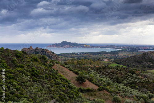 View of Farm Fields and Town on the Sea Coast. Santa Maria Navarrese, Sardinia, Italy. Cloudy and Rainy Sky. photo