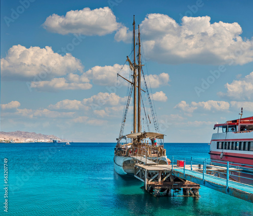 Pleasure sailboats and motorboats anchored near pier in marina of the Red Sea...